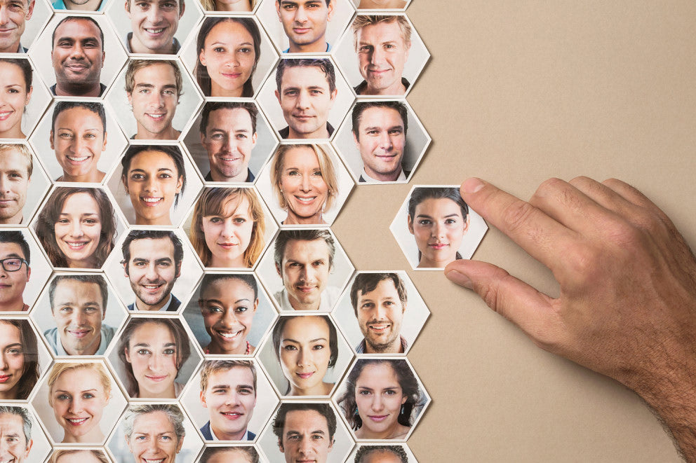 Hand wählt Porträt aus Hexagon-Fotogalerie mit vielen Gesichtern