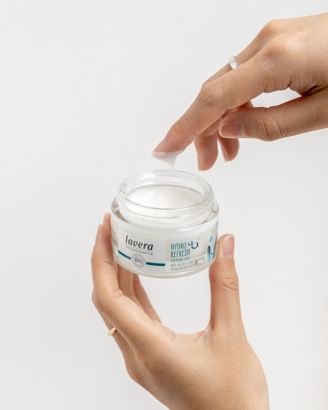 Hand hält Cremetiegel