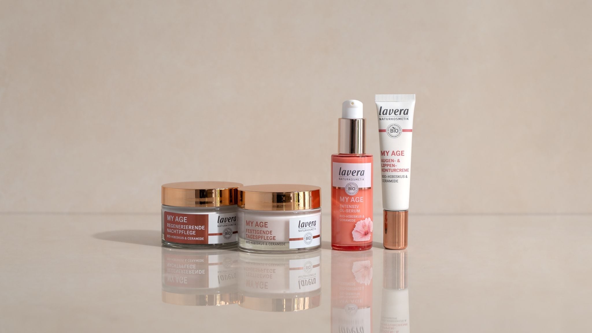 lavera My Age Anti-Age Pflegeprodukte mit Bio-Hibiskus und Ceramiden: Nachtcreme, Tagescreme, Öl-Serum und Augen- & Lippenkonturencreme, dekorativ auf hellem Hintergrund