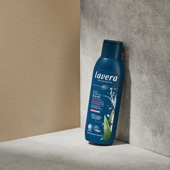 Lavera Basis Sensitive Body Milk in blauer Flasche auf Steinpodest