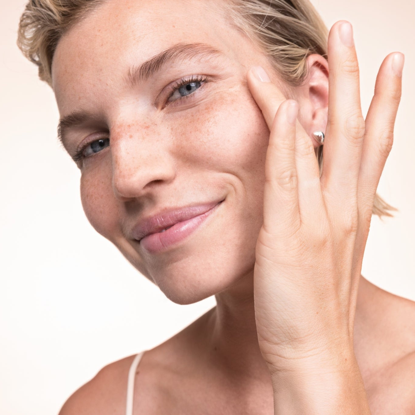 Frau trägt creme auf das Gesicht auf