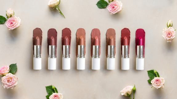 Lavera Lippenstifte in verschiedenen Farben umgeben von rosa Rosen