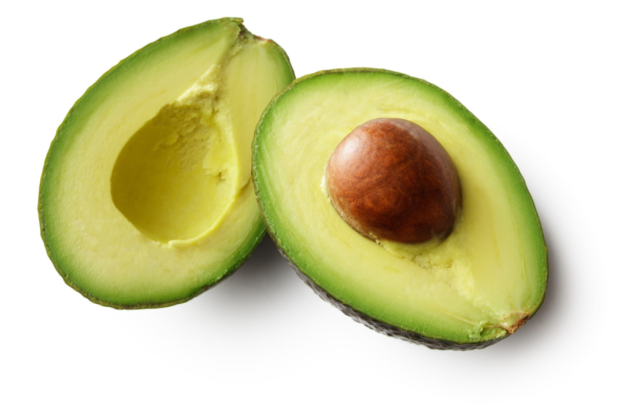 Eine reife Avocado, aufgeschnitten in zwei Hälften, eine mit Kern und eine ohne.