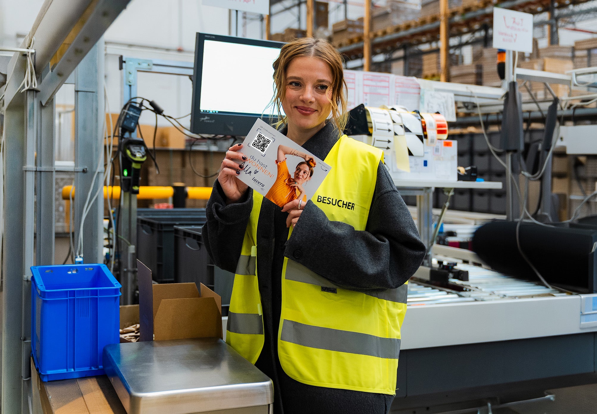 Jella Haase in lavera Logistikzentrum mit Kärtchen in der Hand