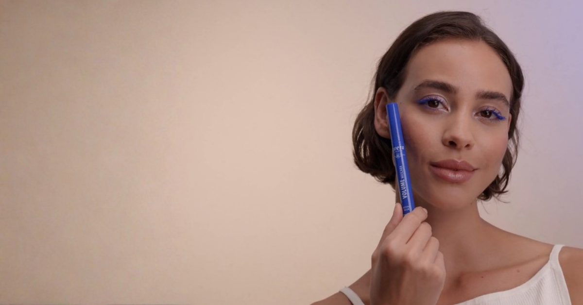 Frau probiert den royal blauen Volume Mascara aus