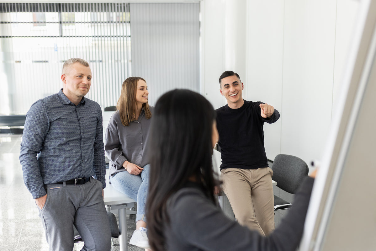 Vier lavera Mitarbeiterinnen und Mitarbeiter in einem hellen Raum mit weißen Wänden