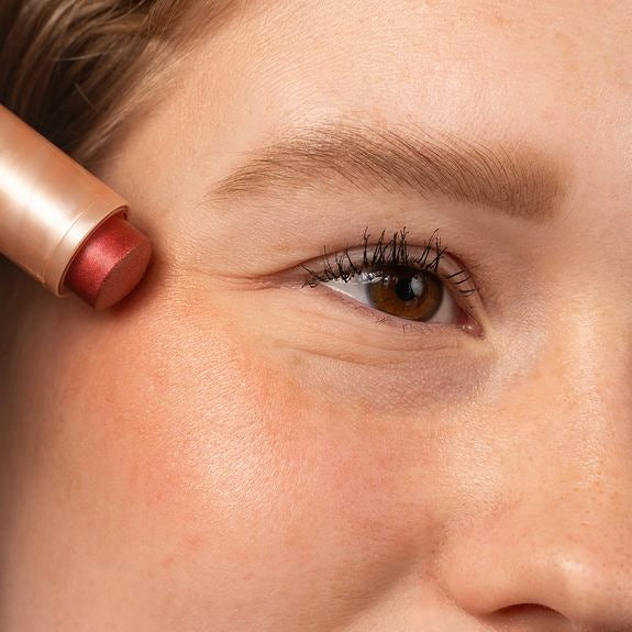 Nahaufnahme beim Auftragen eines Multi Balm Sticks auf die Wange