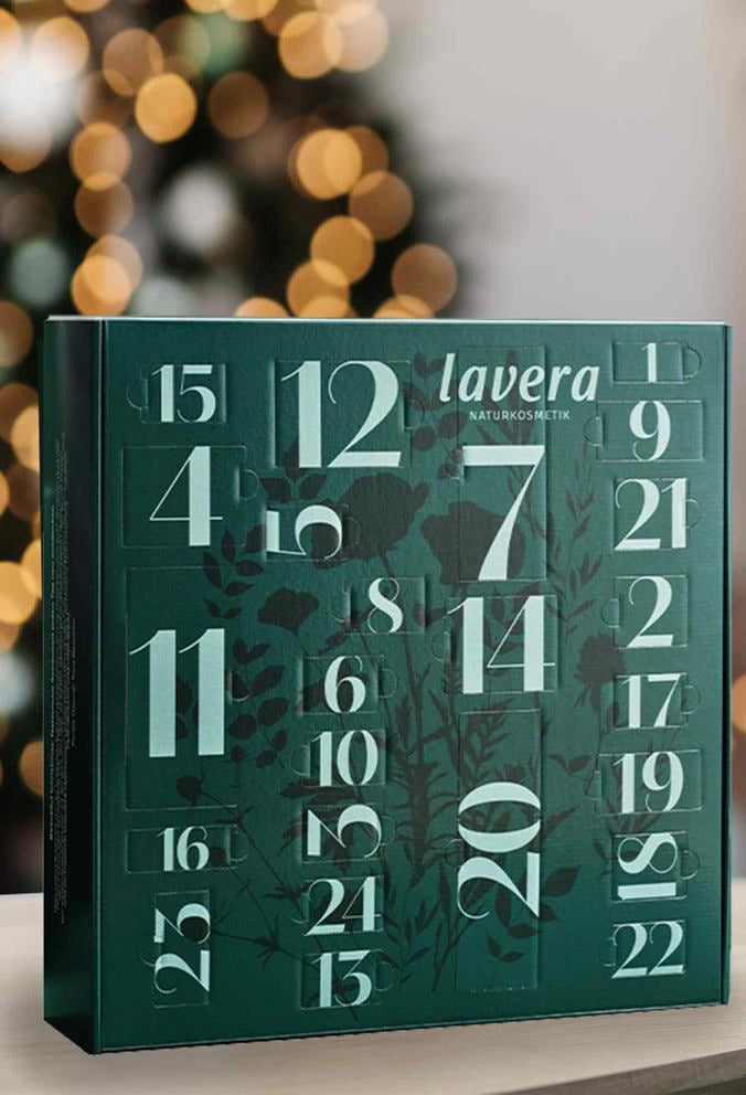 Grüner lavera Adventskalender mit Zahlen, festliche Lichter im Hintergrund