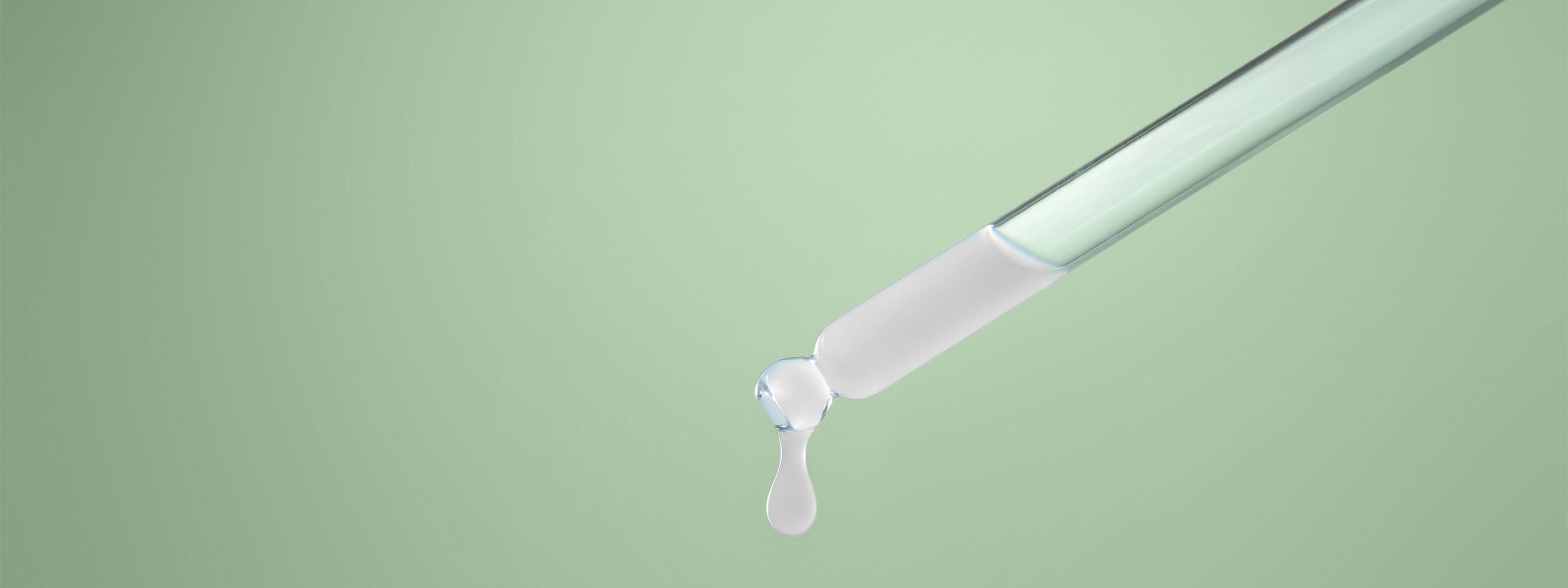 Serum aus Pipette auf grünem Hintergrund