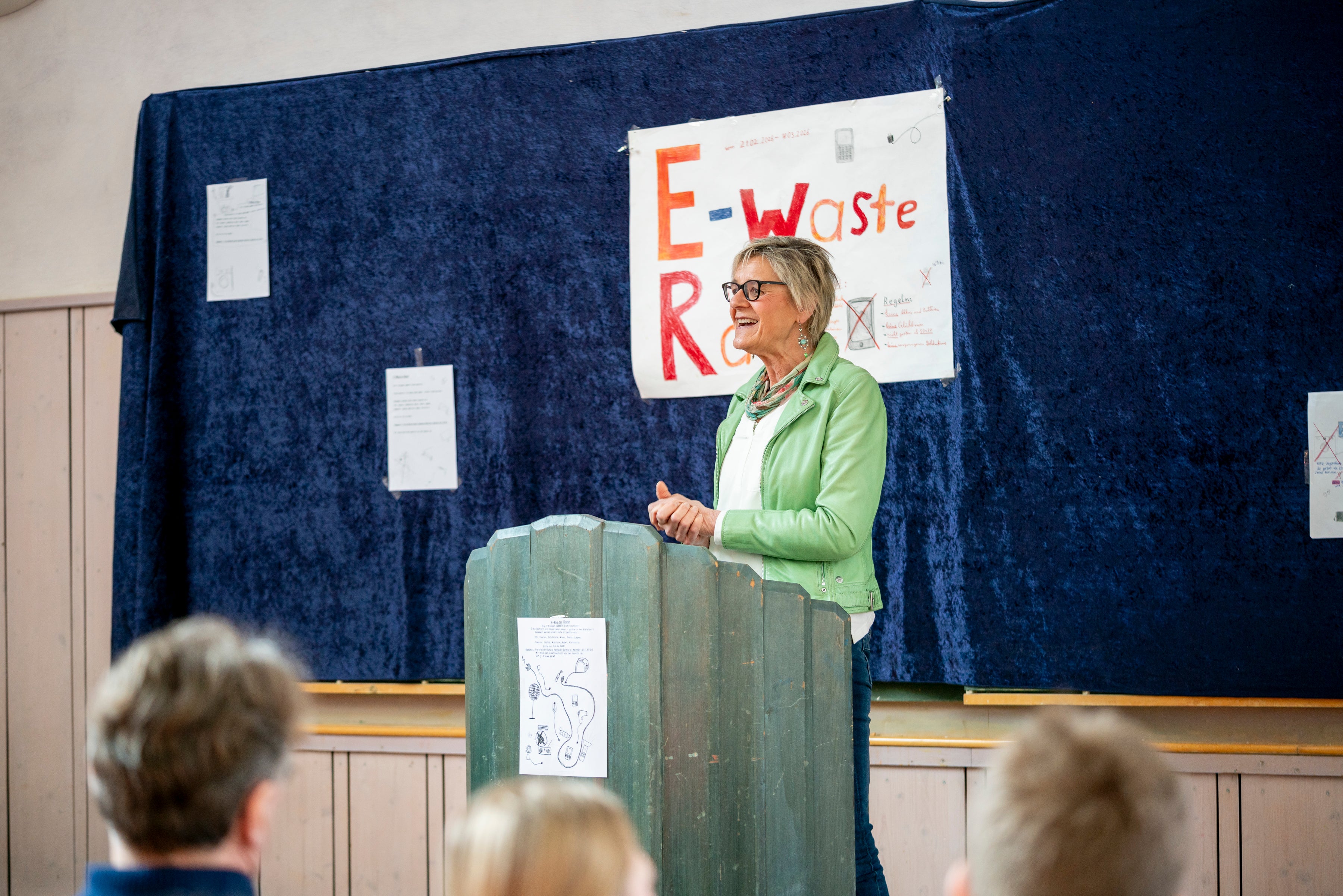 Sabine Kästner steht auf einem Rednerpult vor einer Schulklasse