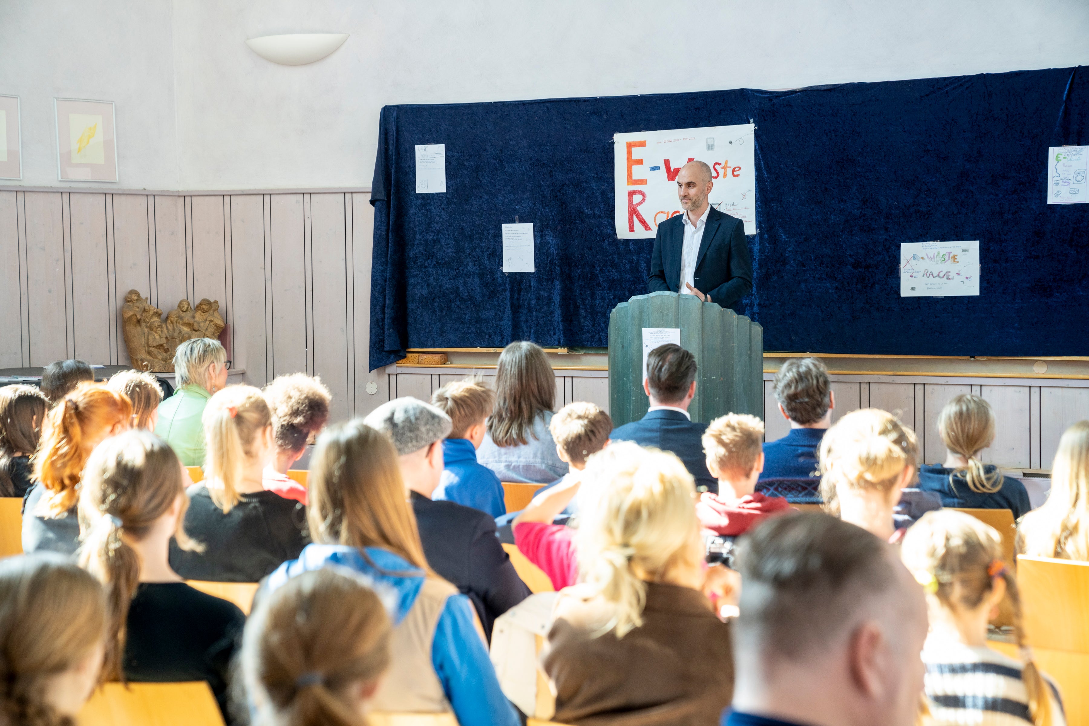 Hannovers Oberbürgermeister steht hinter einem Rednerpult vor einer Schulklasse