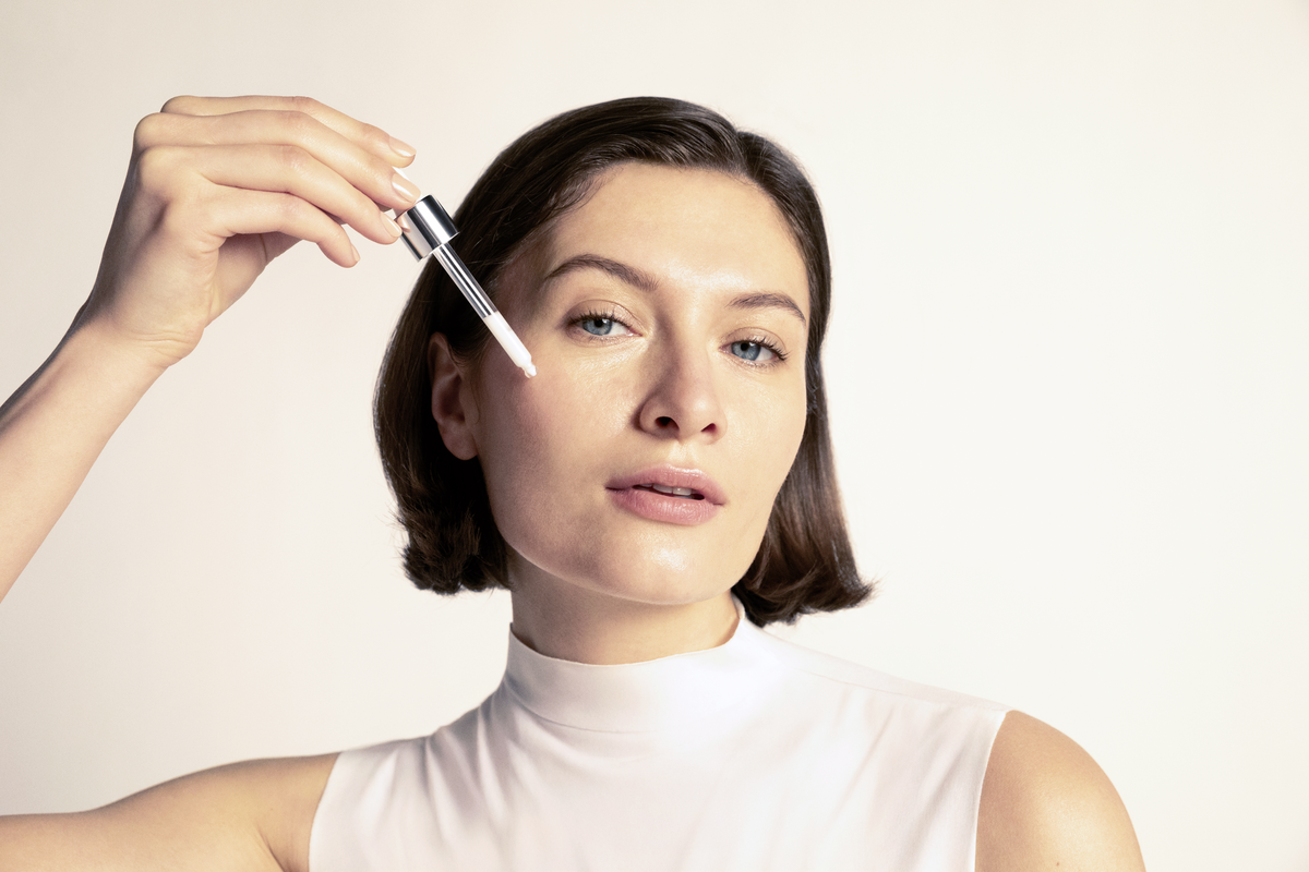 Eine Frau trägt Serum auf ihr Gesicht auf