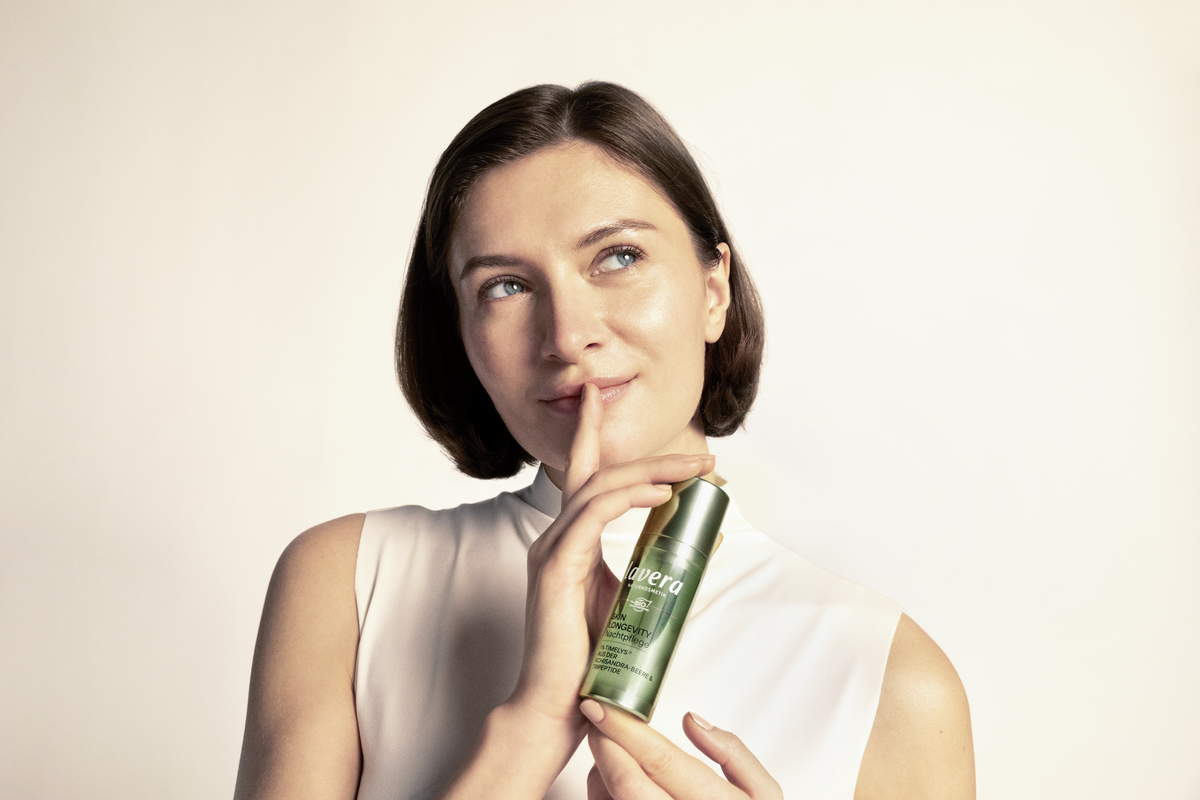 Eine Frau hält die Skin Longevity Tagescreme in der Hand