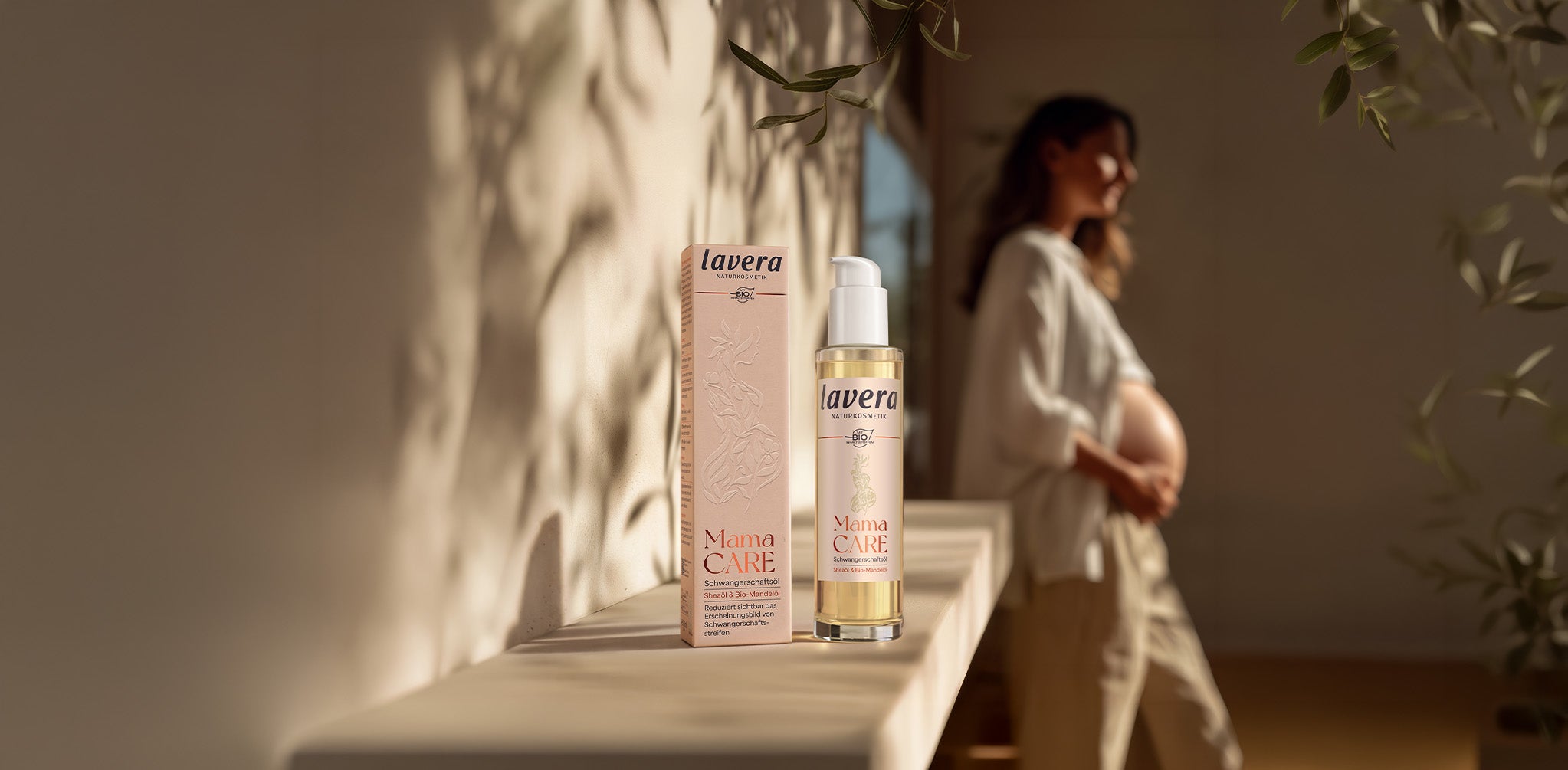 Mama Care Schwangerschaftsöl mit einem schwangeren Frau im HIntergrund