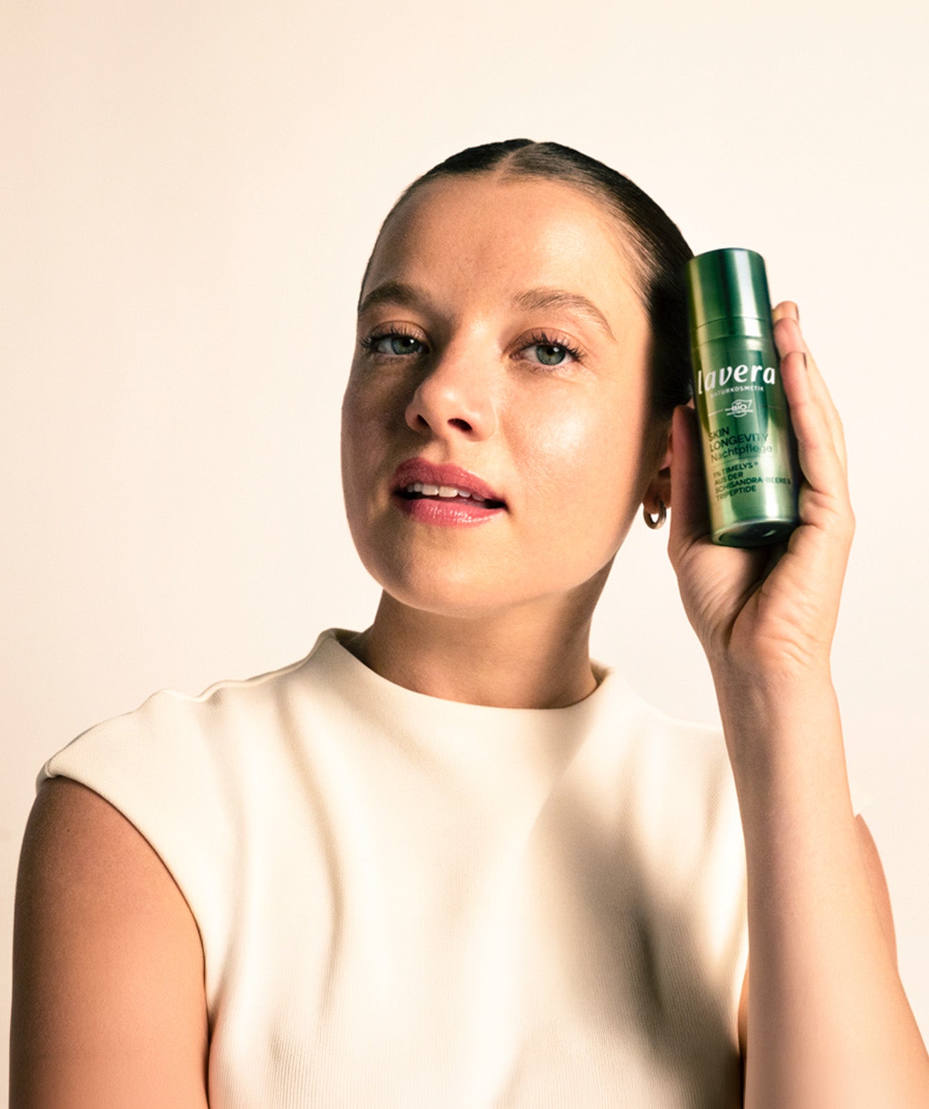 Jella Haase hält Skin Longevity Nachtpflege in der Hand