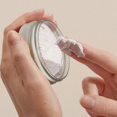 Finger nimmt Creme aus Tiegel, Nahaufnahme