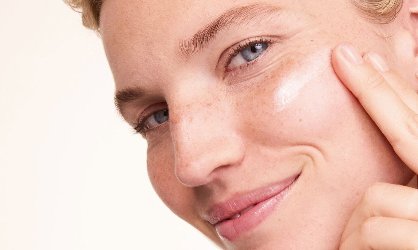 Creme wird auf die Wange aufgetragen