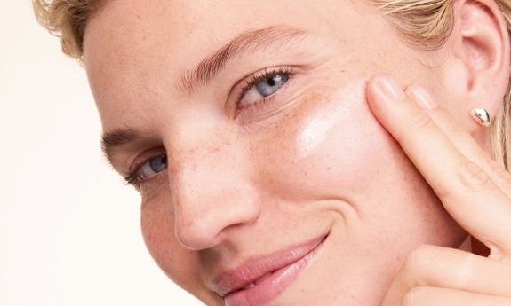 Creme wird auf die Wange aufgetragen