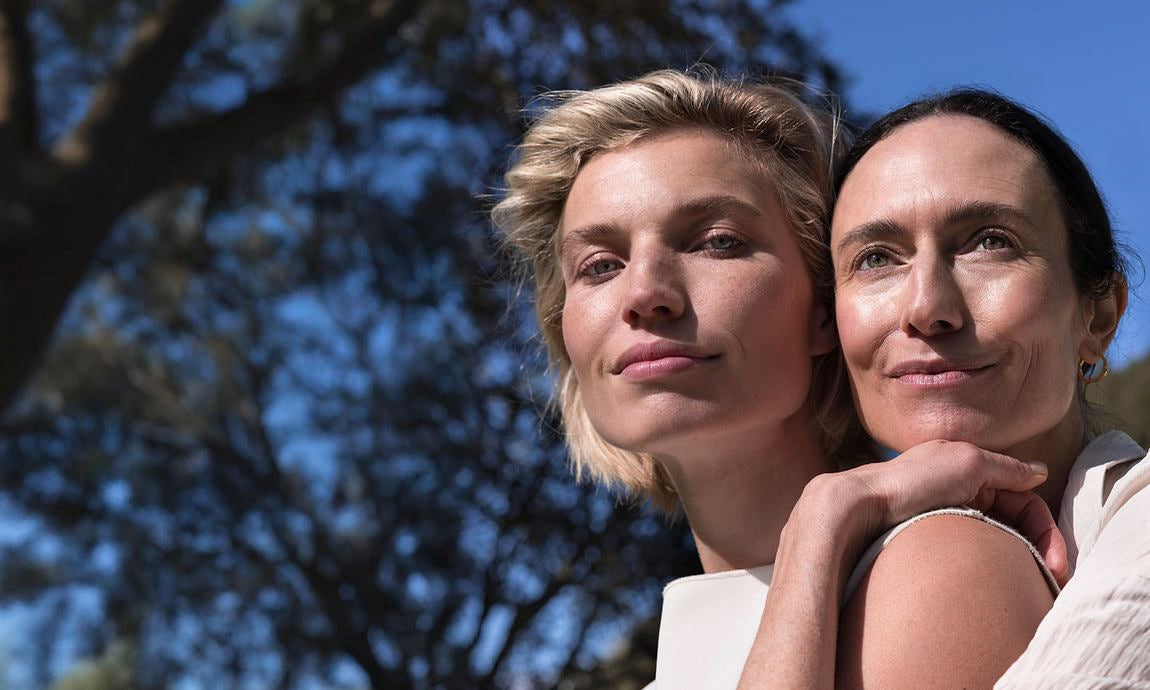 Zwei Frauen im Sonnenlicht, eine umarmt die andere, Porträt im Freien