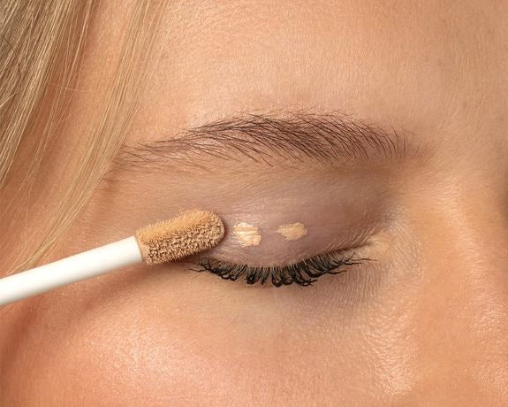 Nahaufnahme eines Augenlids mit Concealer-Auftrag als Lidschatten-Base