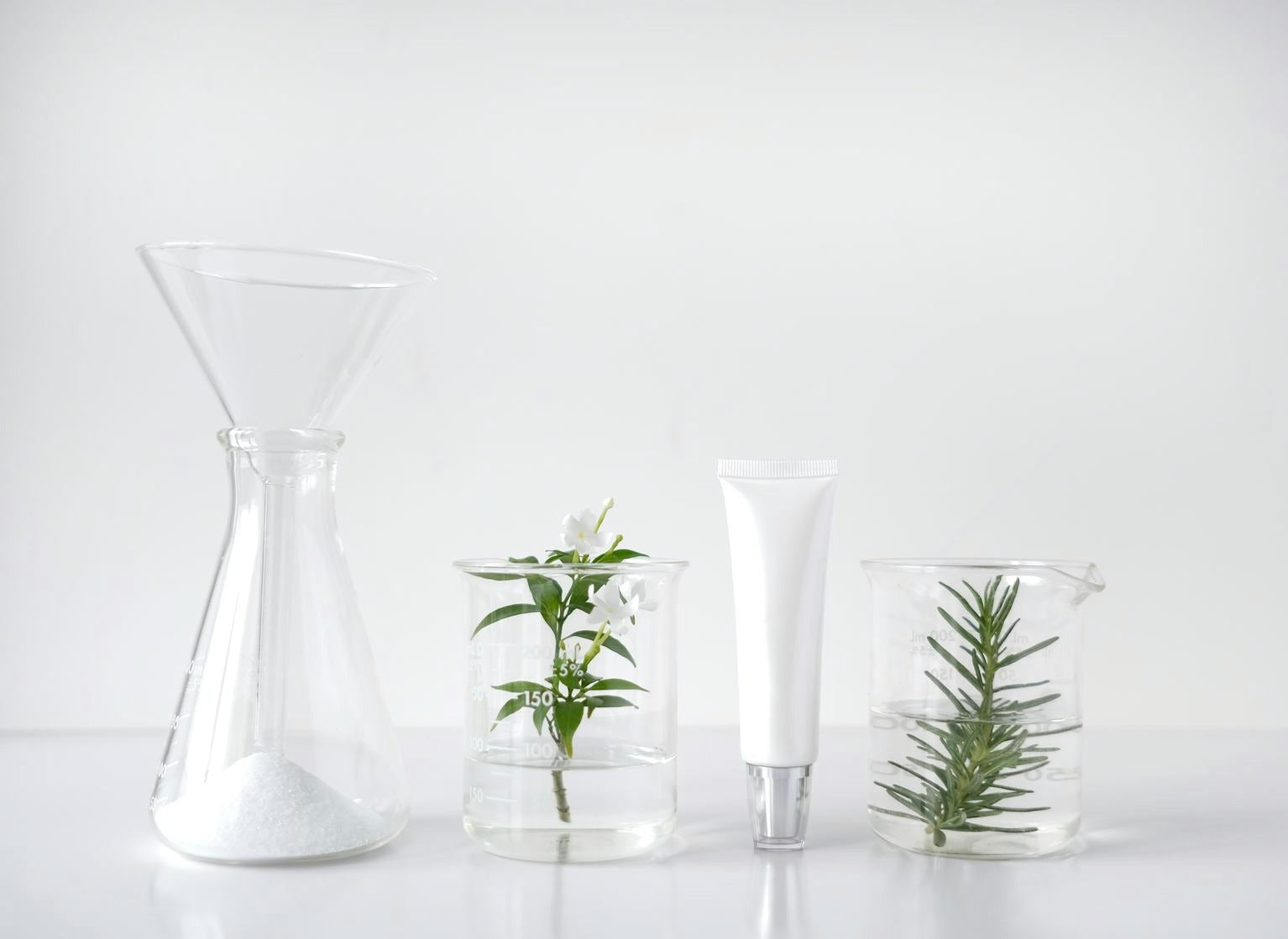 Laboranten im weißen Kittel prüfen Produkte an Arbeitstischen.