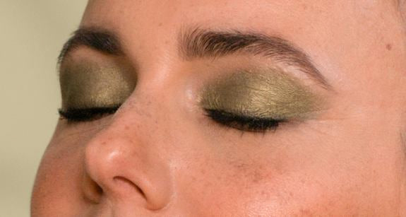 Nahaufnahme der mittleren Gesichtshälfte einer Frau mit dunkelgrünen Augen Make-up in seitlicher Ansicht und geschlossenen Augen