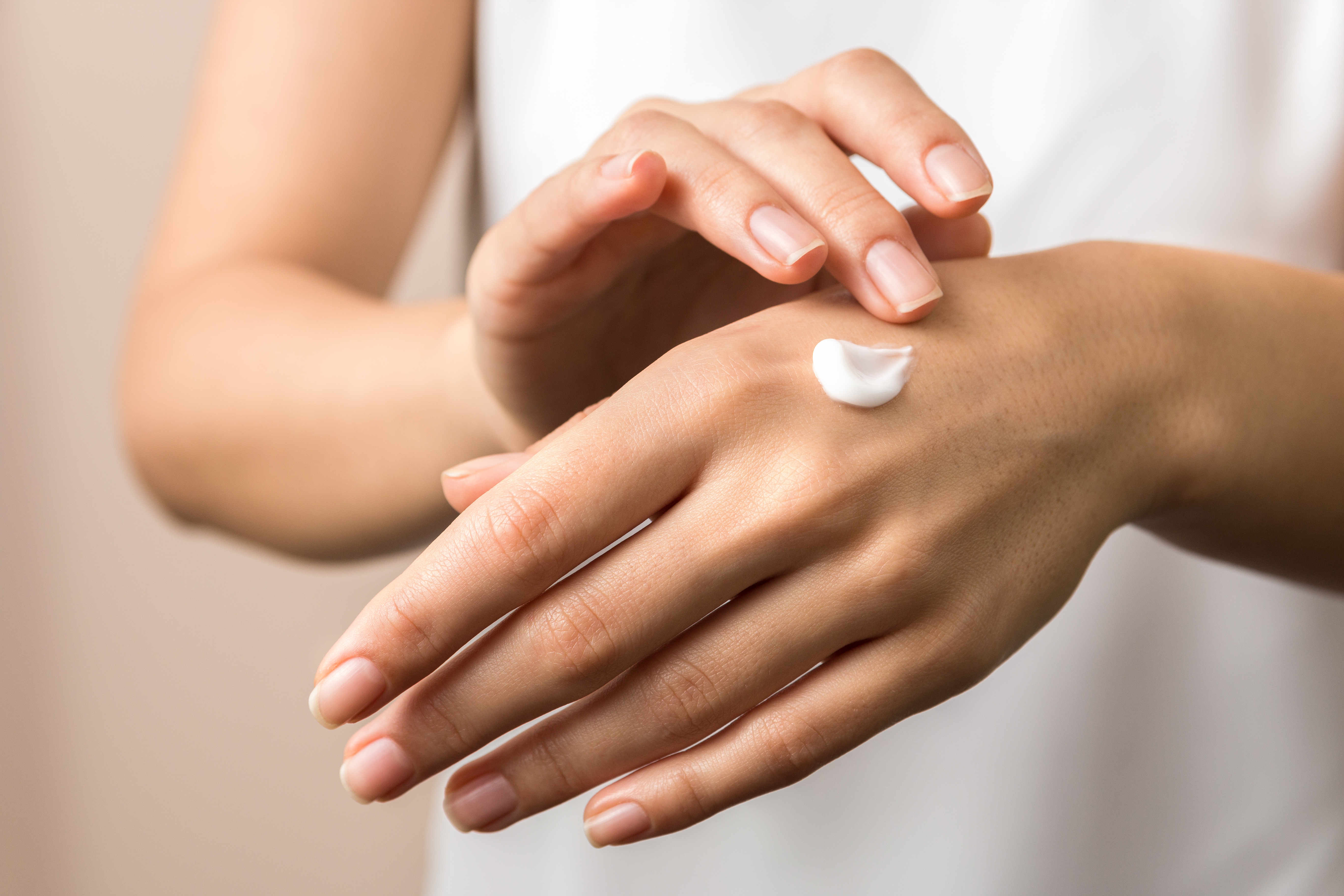 Glycerin-hand-eincremen-stock nahaufnahme von zwei frauenhaenden mit weißer handcreme